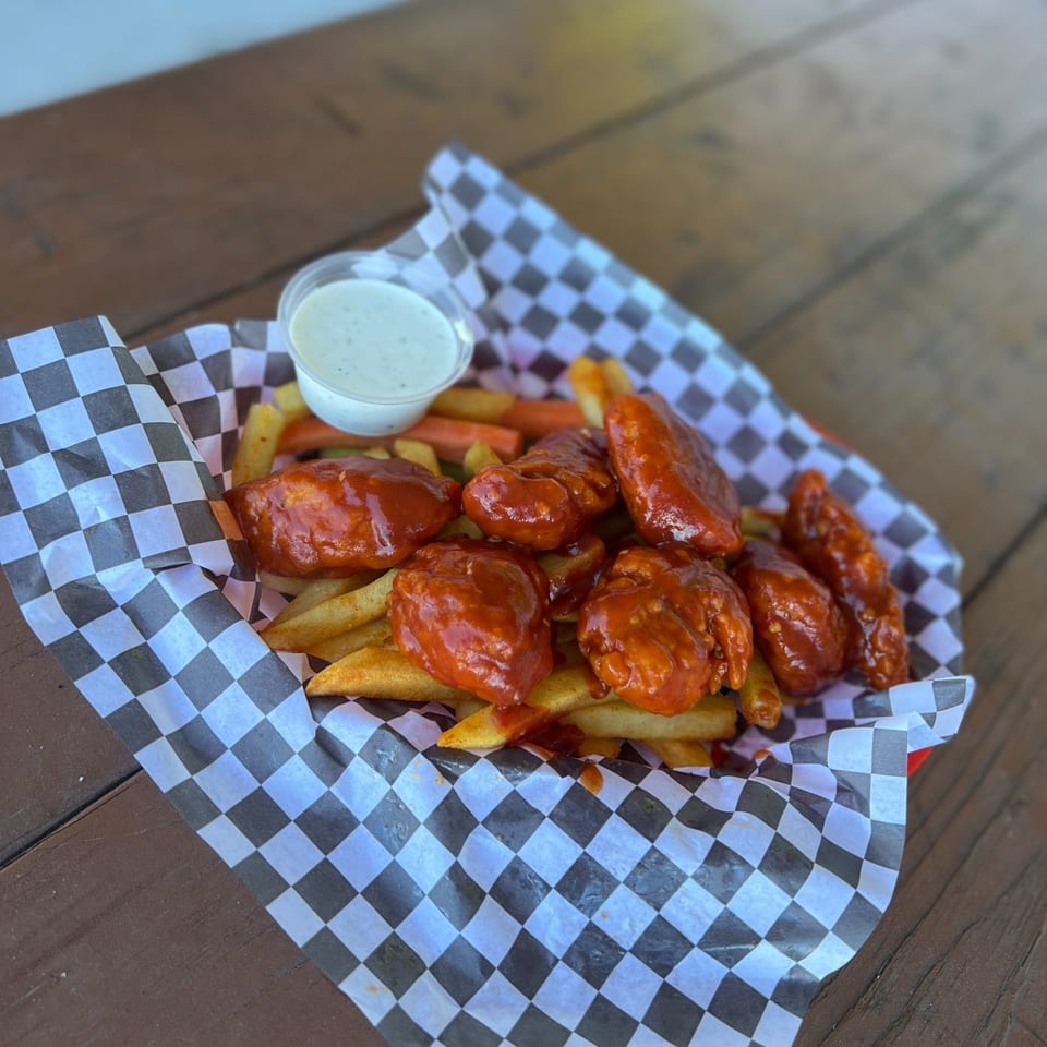 Legends Grill's buffalo wings and fries in a checkered paper-lined basket with a side of ranch.