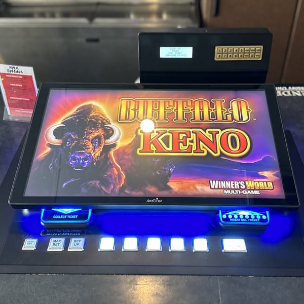 A Buffalo Keno multi-game machine with a glowing blue base and an "April Specials" sign nearby.